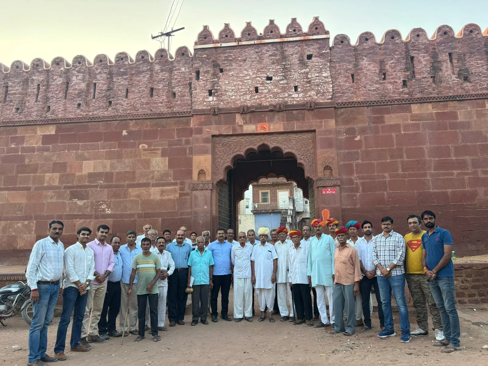 A large group gathered in front of a heritage gateway