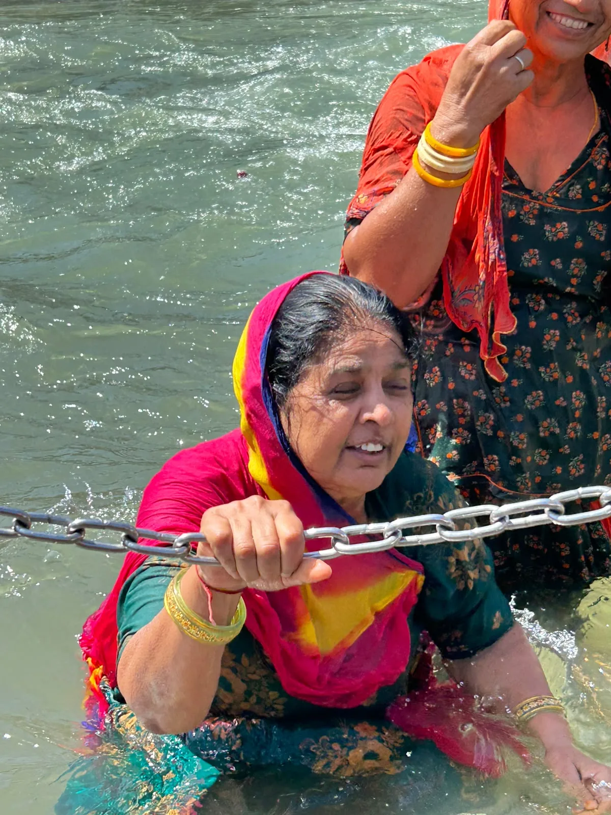A family traveller crossing a river with assistance