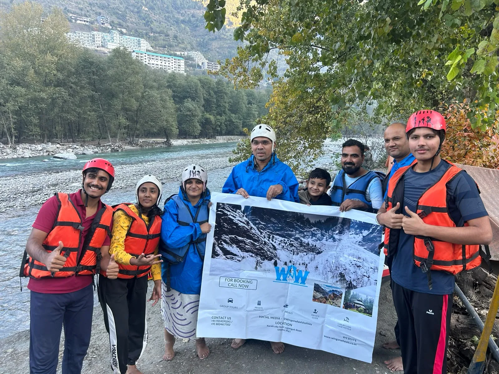 A rafting group holding a Wings and Wheels Holiday banner