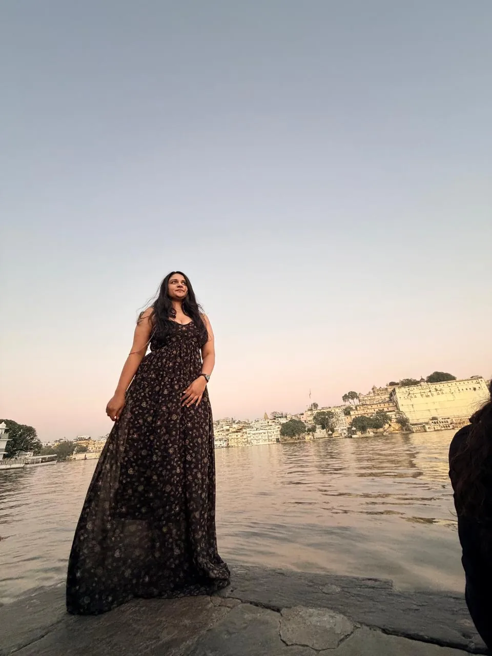 A traveller sitting beside a lake at sunset