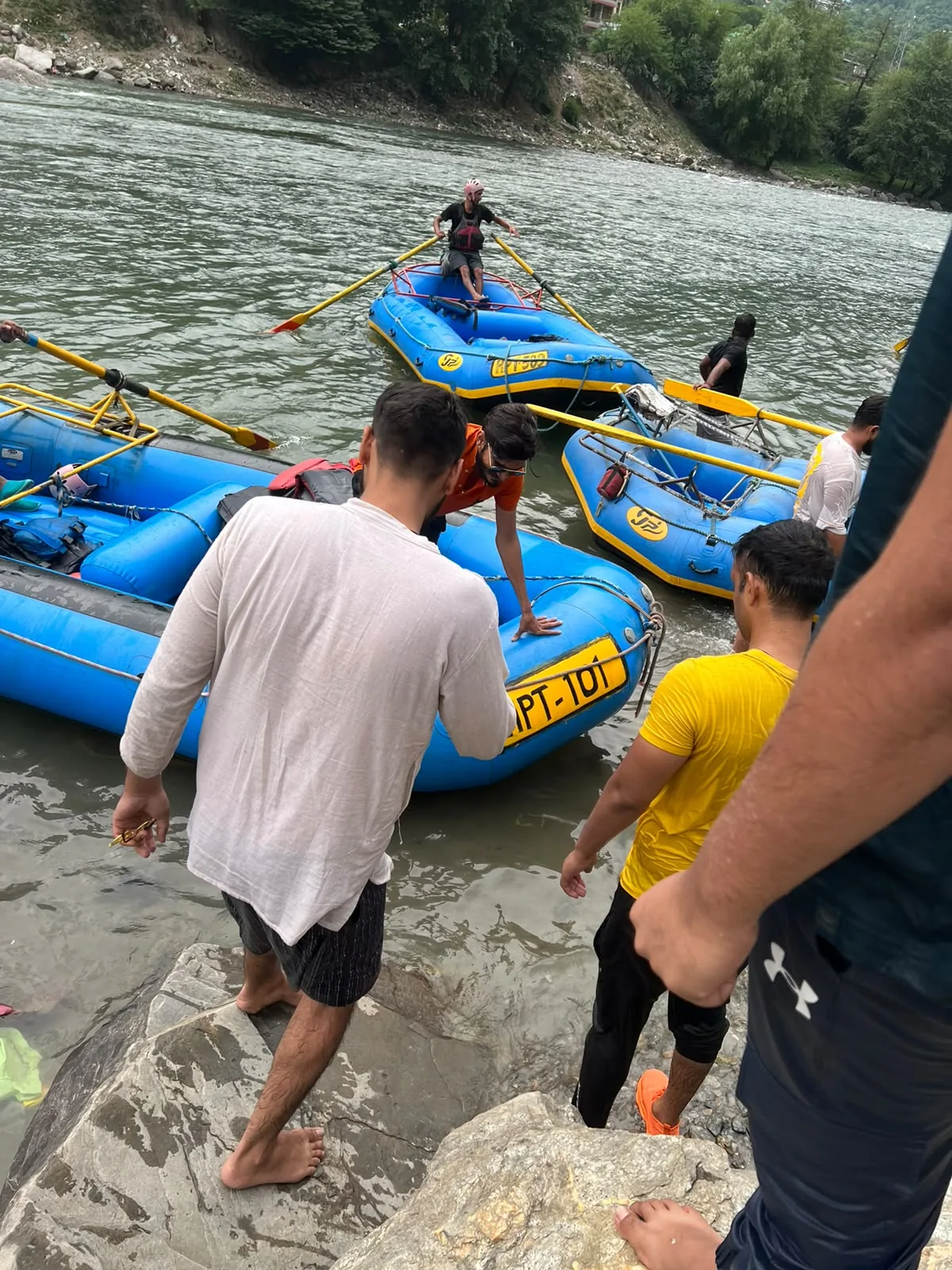 A rafting boat being prepared beside a river