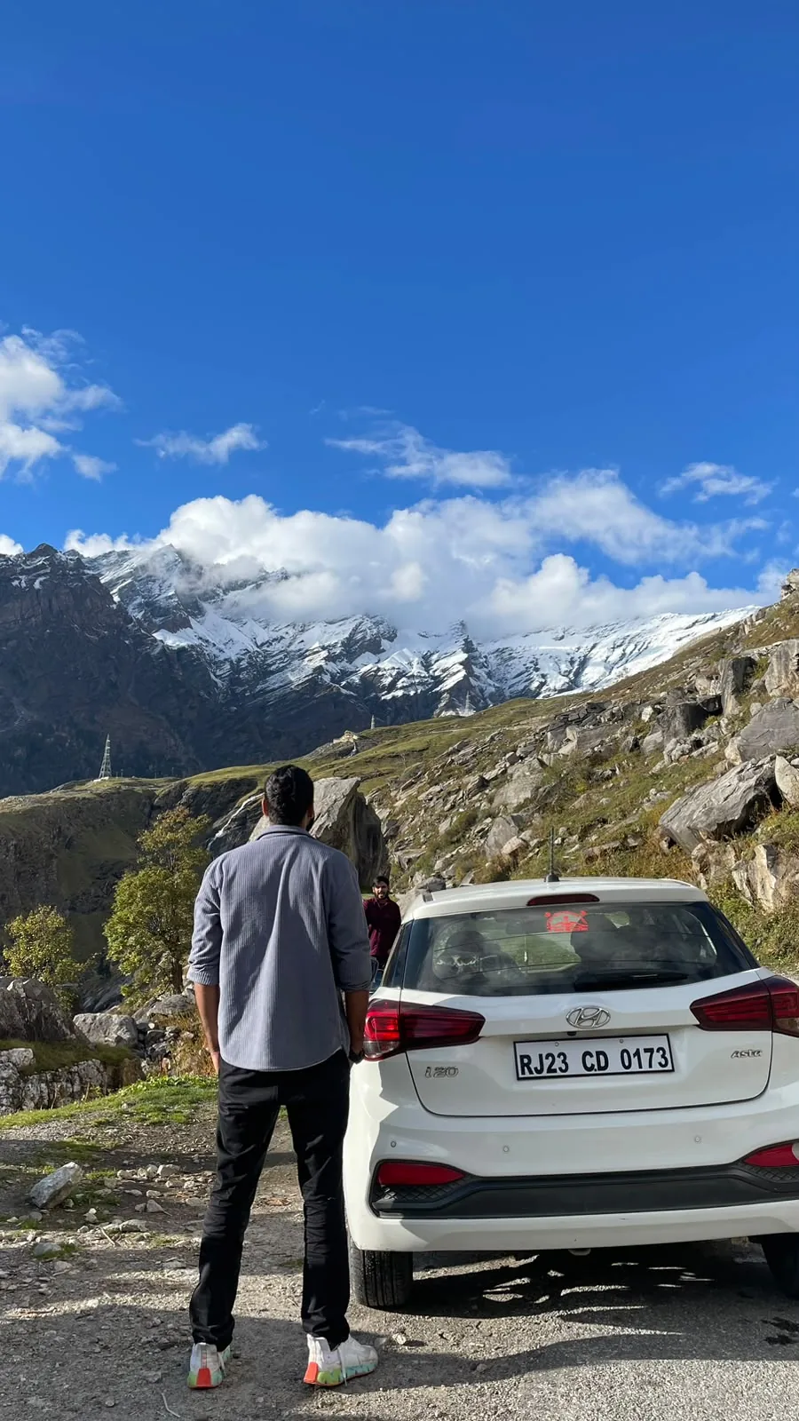 Travellers looking across a dramatic mountain road
